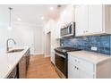 Modern kitchen with stainless steel appliances and a stylish blue backsplash at 412 Carrera Ln, Acworth, GA 30102