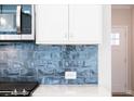 Bright kitchen featuring a blue tile backsplash and stainless steel microwave at 412 Carrera Ln, Acworth, GA 30102