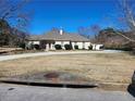 Well-maintained house exterior with a circular driveway, mature trees, and a lush lawn at 1205 Dover Se Pl, Conyers, GA 30013