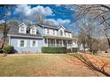 Inviting two-story home showcasing a charming covered front porch, complementing the home's curb appeal, set on a beautifully landscaped lot at 1230 Scenic Brook Sw Trl, Conyers, GA 30094