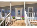 Charming front porch featuring a welcoming entrance with decorative details, complemented by potted plants and stylish exterior lighting at 1230 Scenic Brook Sw Trl, Conyers, GA 30094