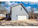 Attached garage with a white door and a driveway, showcasing the home's functional design at 1230 Scenic Brook Sw Trl, Conyers, GA 30094