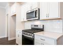 Bright kitchen featuring white cabinets, subway tile backsplash, and stainless steel appliances at 408 Carrera Ln, Acworth, GA 30102