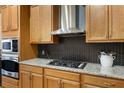 Close up on the kitchen stove, stainless steel range hood, and herringbone backsplash at , Atlanta, GA 30363