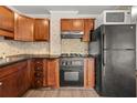 Traditional kitchen features wood cabinets, black appliances, neutral backsplash and laminate countertops at 2285 Peachtree Ne Rd # 1107, Atlanta, GA 30309