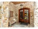 Inviting stone entryway with wood double doors, decorative lighting, and slate tile flooring creates a warm welcome at 4421 Paradise Cir, Vinings, GA 30339