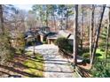 Stunning home features beautiful stone accents, a turret, and a long brick driveway surrounded by trees at 4421 Paradise Cir, Vinings, GA 30339