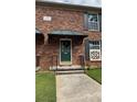 Charming brick townhouse features a green front door, covered entry, and manicured lawn at 5674 Kingsport Dr # 4, Atlanta, GA 30342
