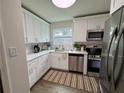 Bright kitchen with white cabinets, stainless steel appliances, and a stylish striped rug at 5674 Kingsport Dr # 4, Atlanta, GA 30342