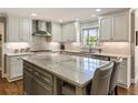 Bright kitchen featuring marble countertops, gray cabinetry, stainless steel appliances and a large island with seating at 741 Bentwood Trce, Alpharetta, GA 30005