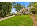 Pictureque home featuring a stone facade, lush green lawn and mature trees at 1993 Mount Vernon Pl, Dunwoody, GA 30338