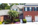 Charming two-story home boasts a brick facade, well-manicured landscaping, and a two-car garage at 2075 Pine Tree Dr, Buford, GA 30518