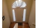 Elegant entryway with wood floors, white door, and arch window adorned with curtains at 903 Tucker Ln, Loganville, GA 30052