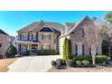 Charming brick home with stone accents, manicured landscaping, and a concrete driveway at 4360 Autry Way, Alpharetta, GA 30022