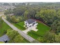 An aerial view of a modern two-story home with a large lot, black fence, and mature trees at 3165 Hall Rd, Dacula, GA 30019