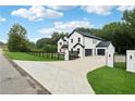 A modern home featuring a long driveway leading to a three-car garage and white and black exterior at 3165 Hall Rd, Dacula, GA 30019