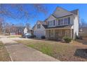 Charming two-story home features a two-car garage, white siding, blue shutters, and manicured landscaping at 4047 Round Stone Trl, Snellville, GA 30039