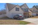 Charming two-story home features a two-car garage, white siding, blue shutters, and manicured landscaping at 4047 Round Stone Trl, Snellville, GA 30039