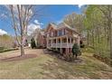 Inviting brick home featuring a spacious front porch and landscaped yard at 4330 Old Oak Trce, Cumming, GA 30041