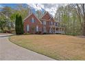 Traditional two-story brick home showcasing a well-maintained lawn and covered entry at 4330 Old Oak Trce, Cumming, GA 30041