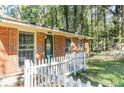 Close-up of a brick home with a green door and a white picket fence at 4479 Richard Rd, Conley, GA 30288