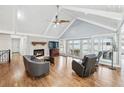 Open living room featuring a stone fireplace, hardwood floors, and large sliding glass doors with lake views at 2387 Battle Dr, Villa Rica, GA 30180