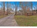 Winding driveway through a wooded landscape leading to the beautiful home at 300 Mill Creek Ct, Acworth, GA 30101
