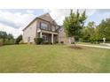 Inviting two-story brick and siding home featuring a lush green lawn and a driveway to an attached garage at 4162 Roberts Crest Dr, Suwanee, GA 30024