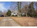 Quaint home with a long driveway, surrounded by mature trees, and a well-manicured lawn at 2033 Old Newnan Rd, Carrollton, GA 30116