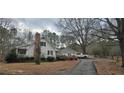 Rear view of home with detached garage and long driveway on a large lot featuring mature trees at 3640 Chandler Haulk Rd, Loganville, GA 30052