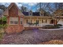 Classic home featuring brick accents, a covered front porch, and beautiful, mature trees at 424 Cannonball Ct, Stockbridge, GA 30281