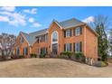 Two-story brick home with a large front lawn and a prominent arched window at 12065 Wexford Club Dr, Roswell, GA 30075