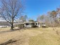 Single story home with a covered carport on a large grassy lot under a clear blue sky at 74 Sandy Path, Rockmart, GA 30153
