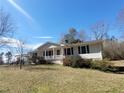 Inviting single-story home with a covered carport, small porch, and lush landscaping at 74 Sandy Path, Rockmart, GA 30153