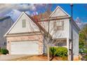 View of a charming two-story home with gray siding and brick accents, showcasing its curb appeal at 1340 Aster Ives Dr, Lawrenceville, GA 30045