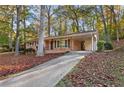 Driveway leading to charming brick home with covered carport, surrounded by mature trees at 2740 Pasco Se Ln, Atlanta, GA 30316