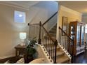 Staircase featuring carpeted steps, dark railings, and trim, complemented by neutral wall colors and decor at 801 Rutledge Ct, Woodstock, GA 30188