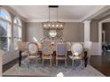 Elegant dining room with a large table, decorative chandelier, and arched windows at 6305 Deerwoods Trl, Alpharetta, GA 30005