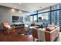 Open living room with hardwood floors, stylish furnishings, and expansive windows offering city vistas at 45 Ivan Allen Jr Nw Blvd # 1706, Atlanta, GA 30308