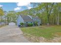 The home features a long drive leading to a multi-car garage with a spacious, treed yard at 3430 Pate Rd, Snellville, GA 30078