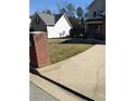 View of front yard shows the lawn, driveway, brick mailbox, and house, but the grass is dry and not appealing at 10 Chapman Way, Covington, GA 30016