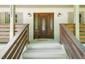 Close up of an elegant, dark wood front door with decorative glass and stylish sconces at 2647 Wood Hollow Dr, Dunwoody, GA 30360