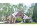 A stunning brick home framed by beautiful, mature trees and a well-manicured lawn at 3280 Peace Ln, Suwanee, GA 30024