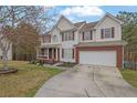 Charming two-story home featuring a brick-accented garage, front porch, and well-maintained landscaping at 1514 Log Cabin Ln, Lawrenceville, GA 30045