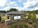 Stone sign welcomes you to the Lakecrest community, surrounded by lush greenery at 1769 Rowland Pass, Buford, GA 30518