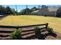 Large, open lot showcasing a well-kept lawn and framed by a classic split-rail fence at 1769 Rowland Pass, Buford, GA 30518
