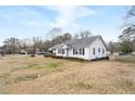 Well-maintained single-story home on a large, grassy lot with mature trees at 116 Poplar St, Fairburn, GA 30213