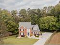 Picturesque aerial view of a home with lush green surroundings and a long driveway at 3500 Parkwood Hills Ct, Snellville, GA 30078