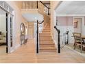Spacious foyer with hardwood floors, staircase, and view into adjacent dining room at 650 Village Crest Dr, Suwanee, GA 30024
