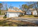 Side view of a home with a well-manicured lawn, large driveway, and an attached garage at 981 Cobb Place Manor Dr, Marietta, GA 30066